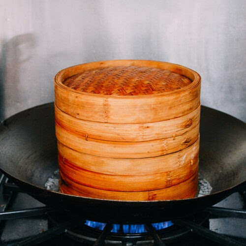 bamboo steamer on boiling water in wok