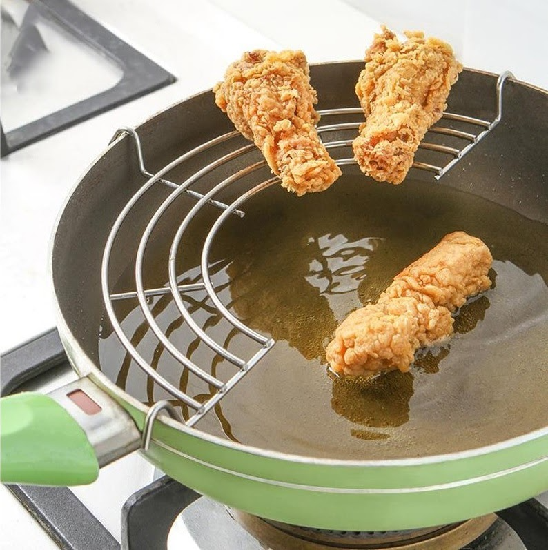 crispy deep frying in oil with chicken on drying wok rack.