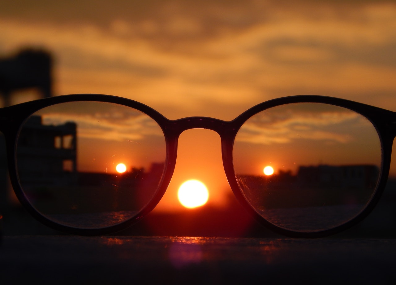 Glasses with focus on more of the background. Center image shows larger sunset foreground.